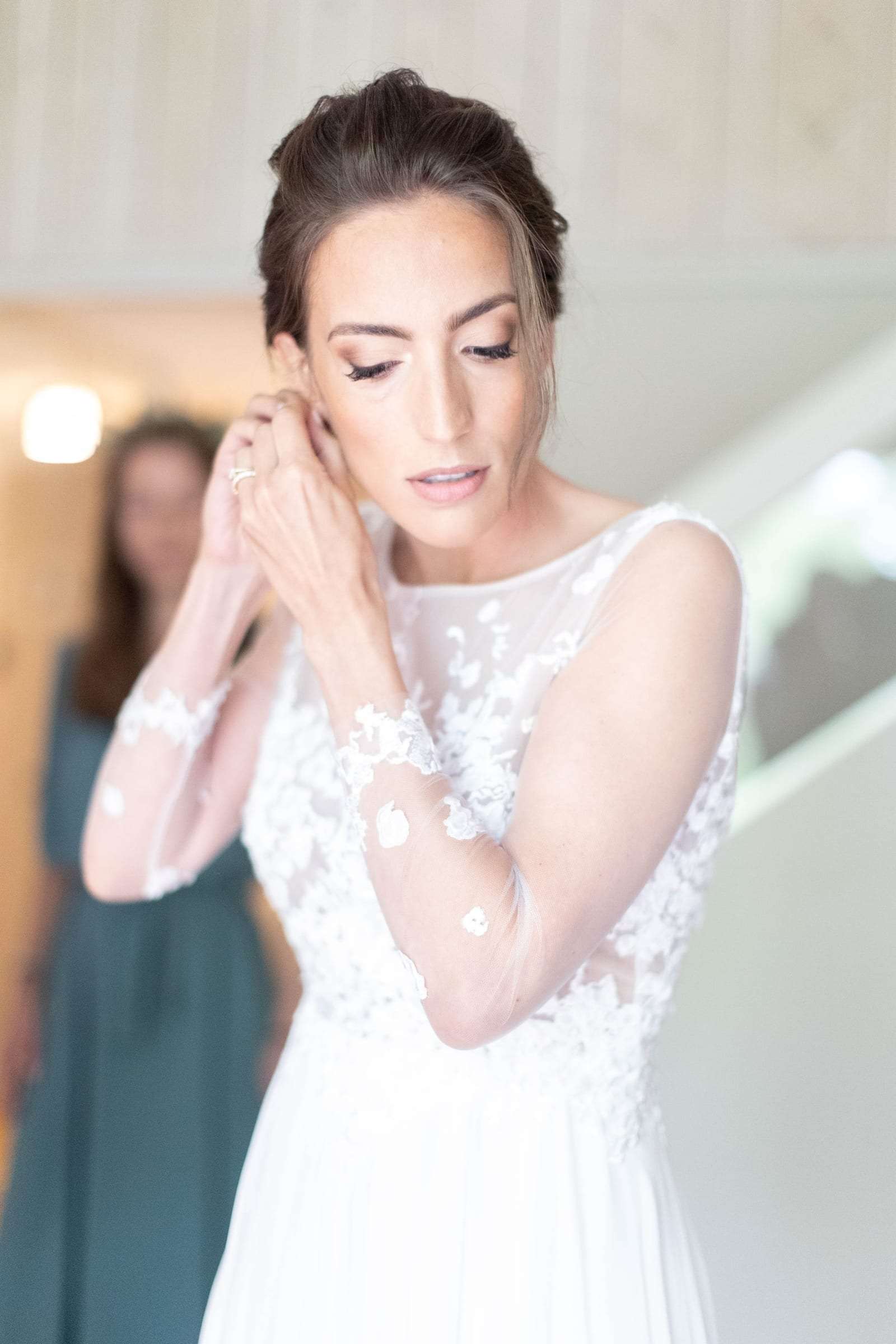La mariée ajuste ses boucles d'oreilles