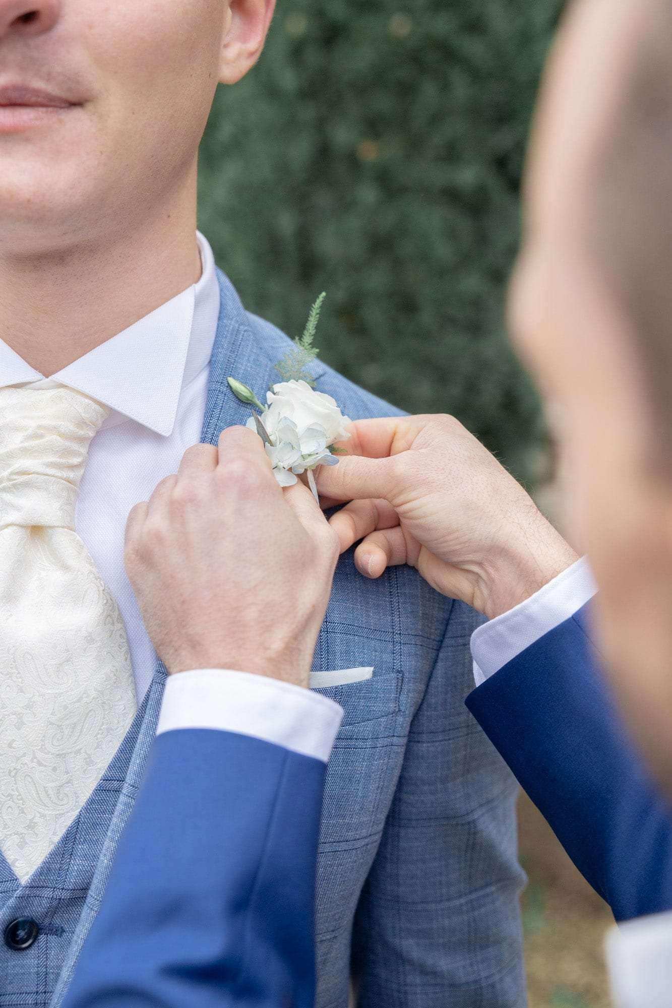 Le témoin épingle la boutonnière du marié